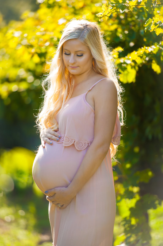 niagara on the lake winery maternity photoshoot outside, long blond hair young mother in golden hour light