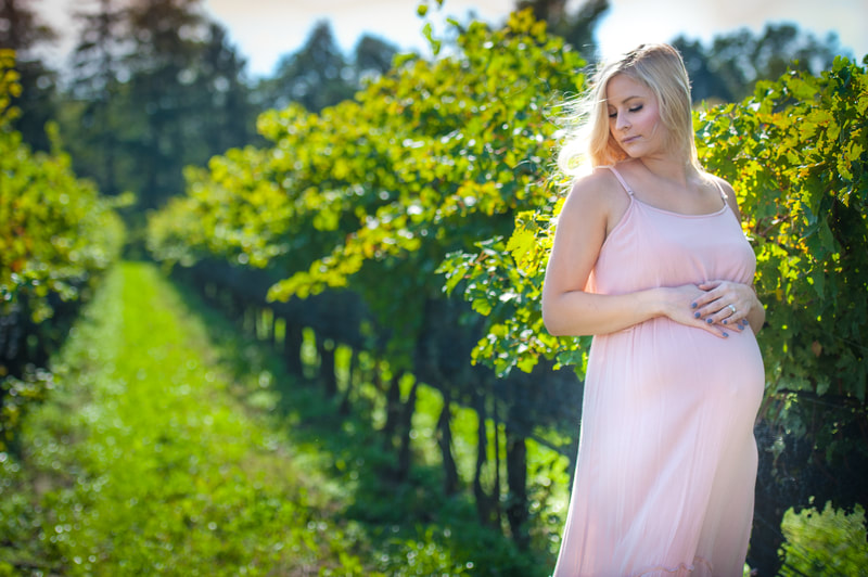 niagara on the lake winery maternity photoshoot outside, young mother posed in midday sunlight in pink dress